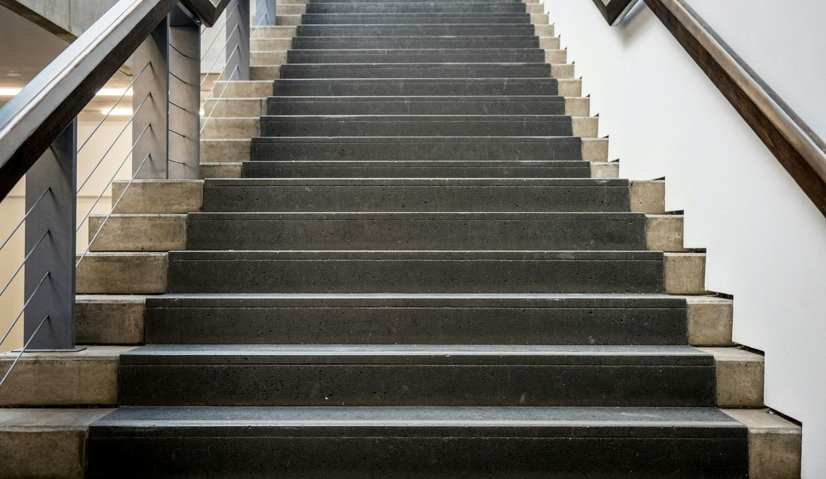 Een propere trap in beton met een leuning
